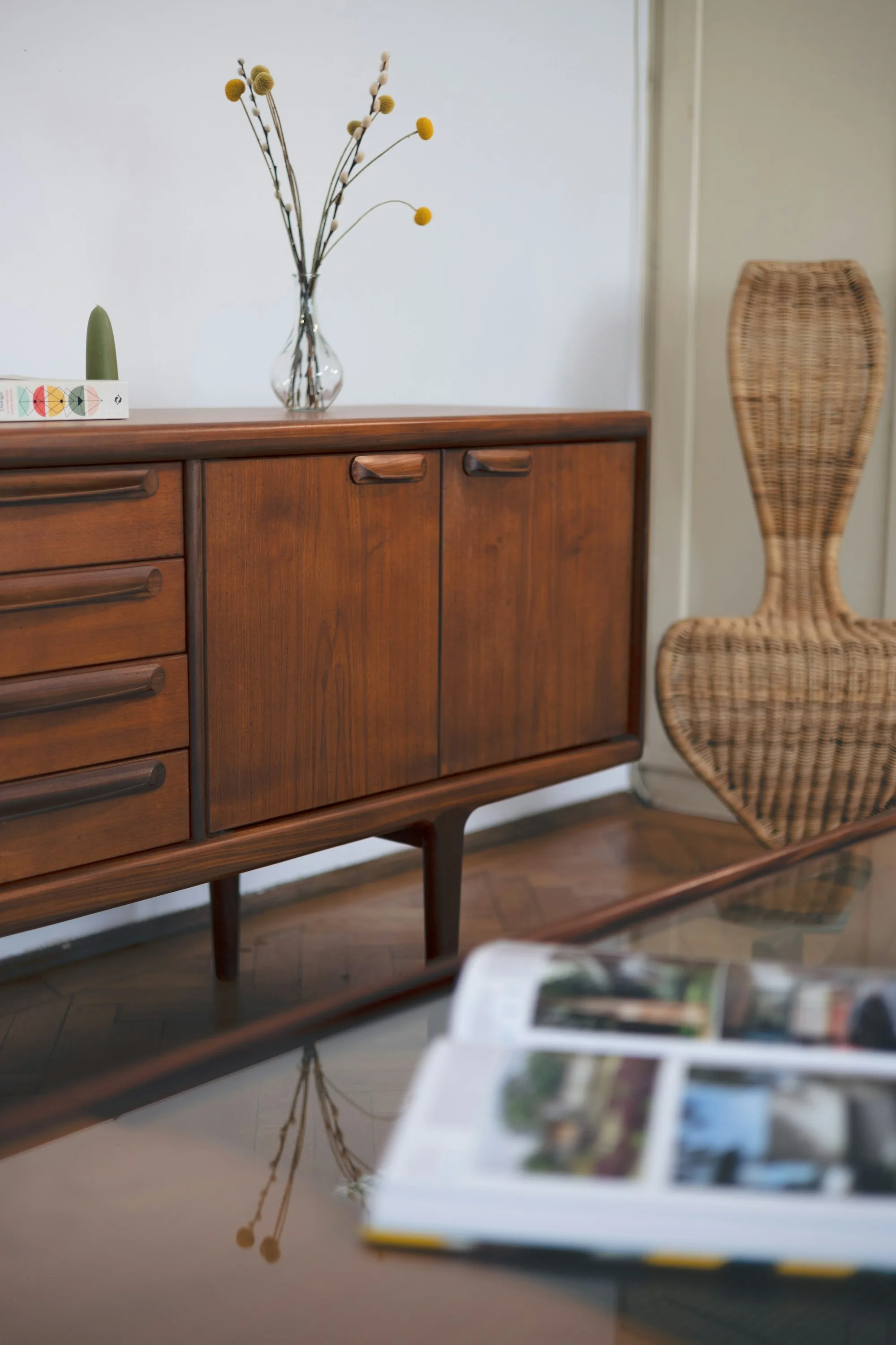 Close-up of a teak mid-century sideboard with sculpted solid wood handles and tapered legs